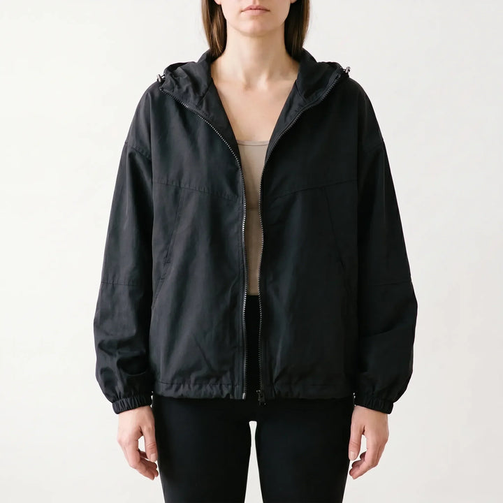 Stylish women's full-zip hooded windbreaker jacket, ideal for layering and casual wear during spring and fall.