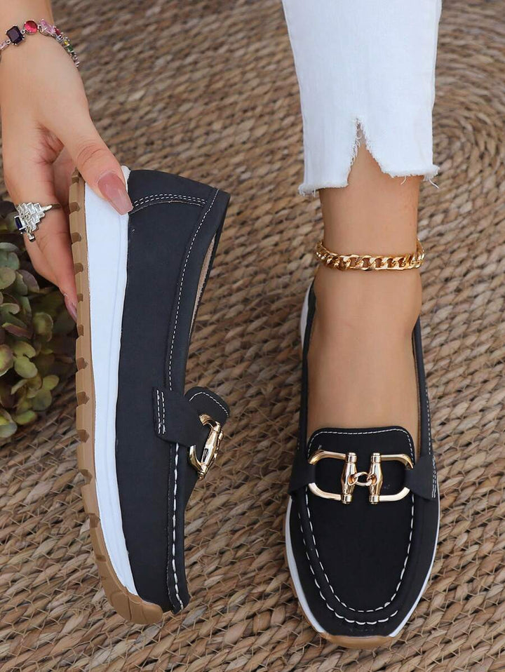 Comfortable women's gold chain flatform loafers worn on foot, perfect for everyday comfort and casual fashion.