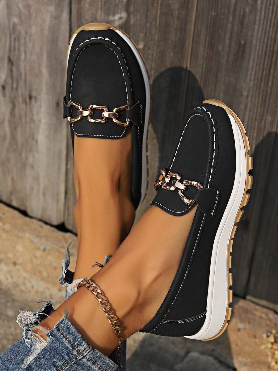 Detail shot of material texture on women's flatform loafers, featuring stylish gold chain & comfortable design.