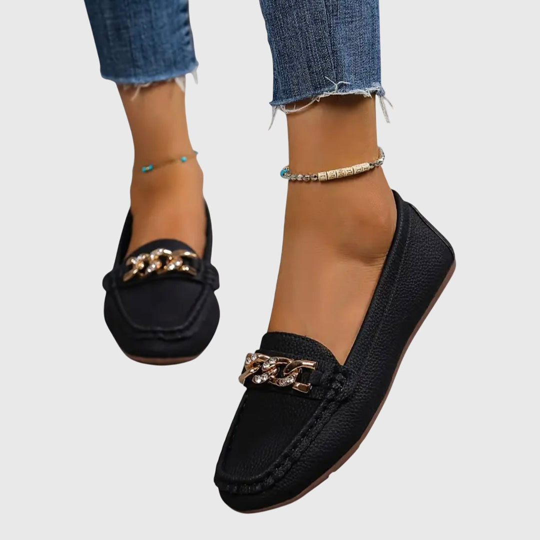 Chic women's wedge loafers featuring a decorative gold chain and sparkling crystal accents.