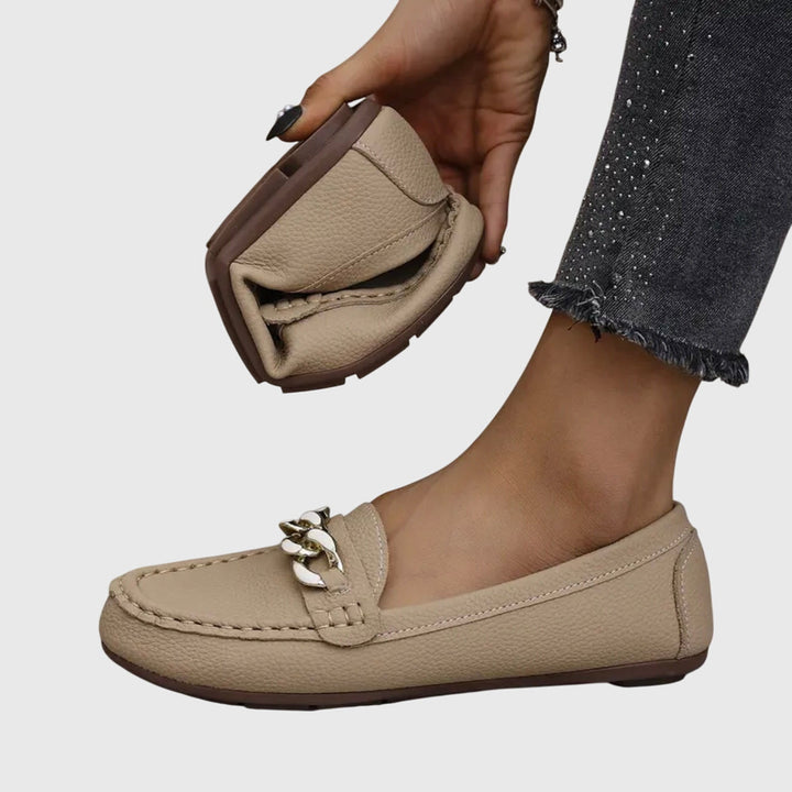 Dressy women's wedge loafers with a sophisticated gold chain and eye-catching crystal embellishment.