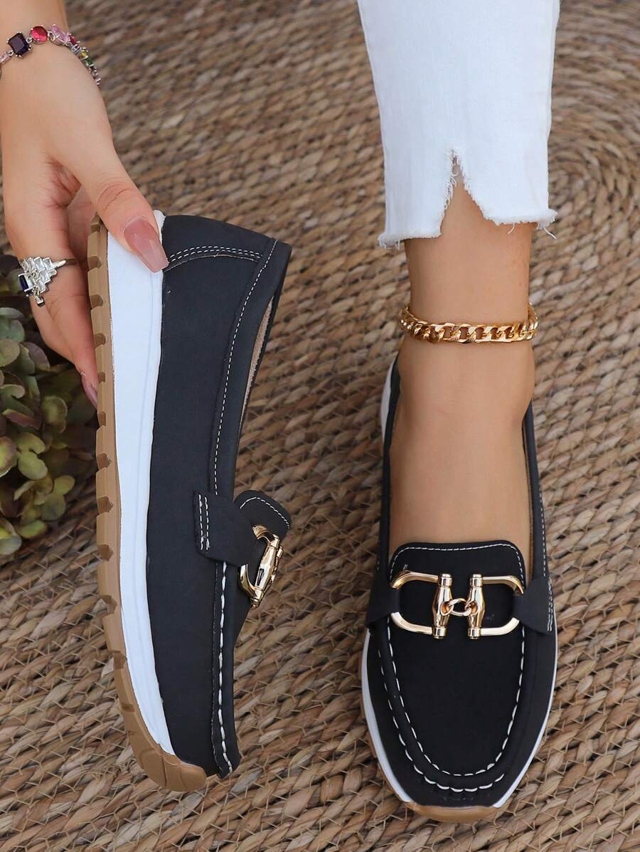 Black women's gold-trim horsebit loafers. Classic slip-on comfort, elegant footwear for any occasion.