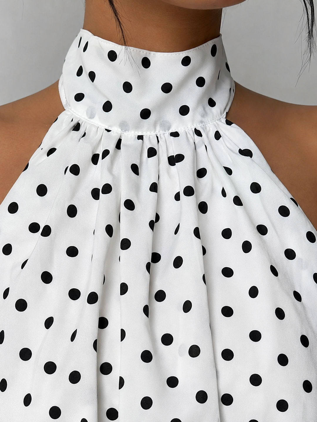 Elegant sleeveless halter mini dress for women, flowy trapeze fit, open back & chic ruffle hem.