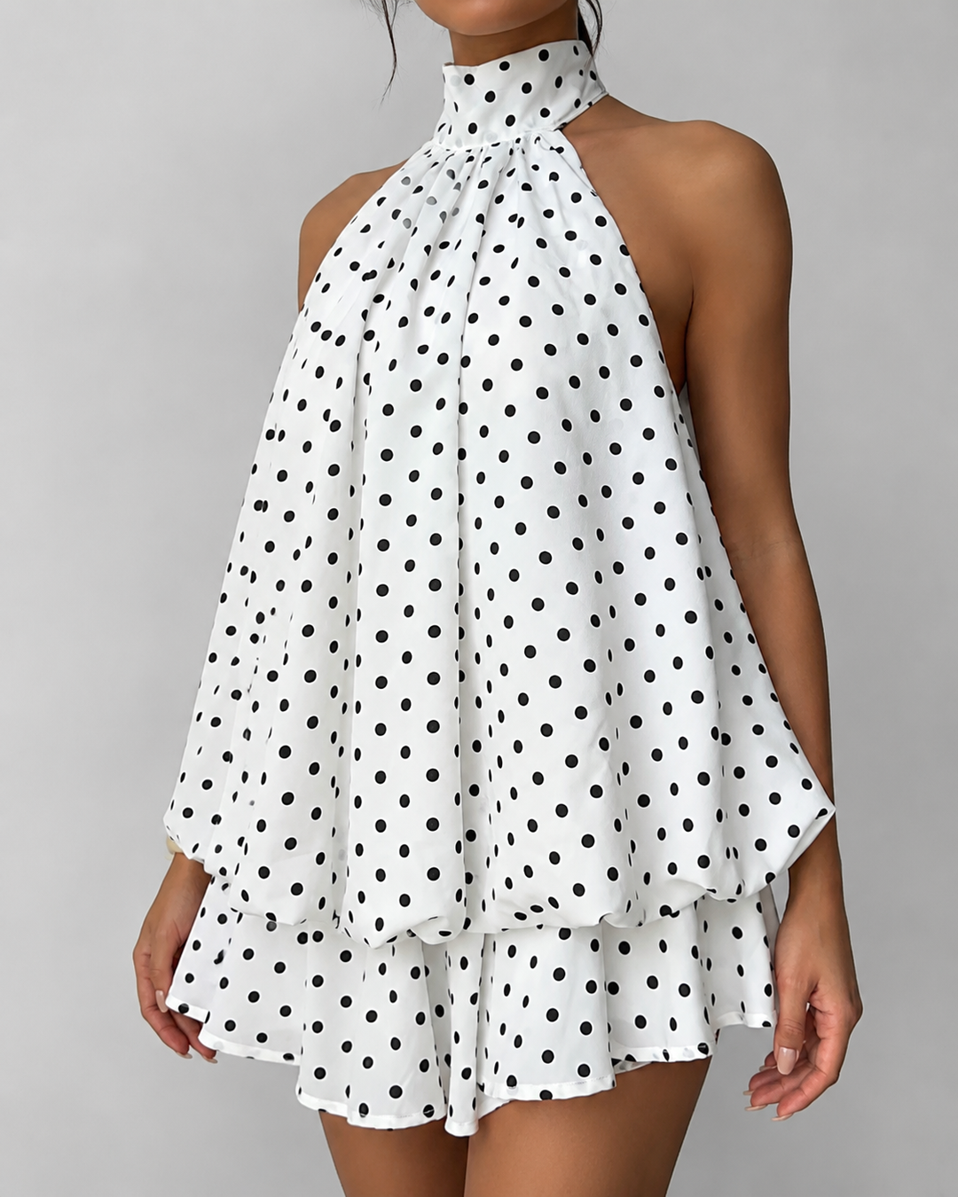 Party-ready women's halter mini dress, open back, playful ruffle hem. Ideal for summer fashion events.
