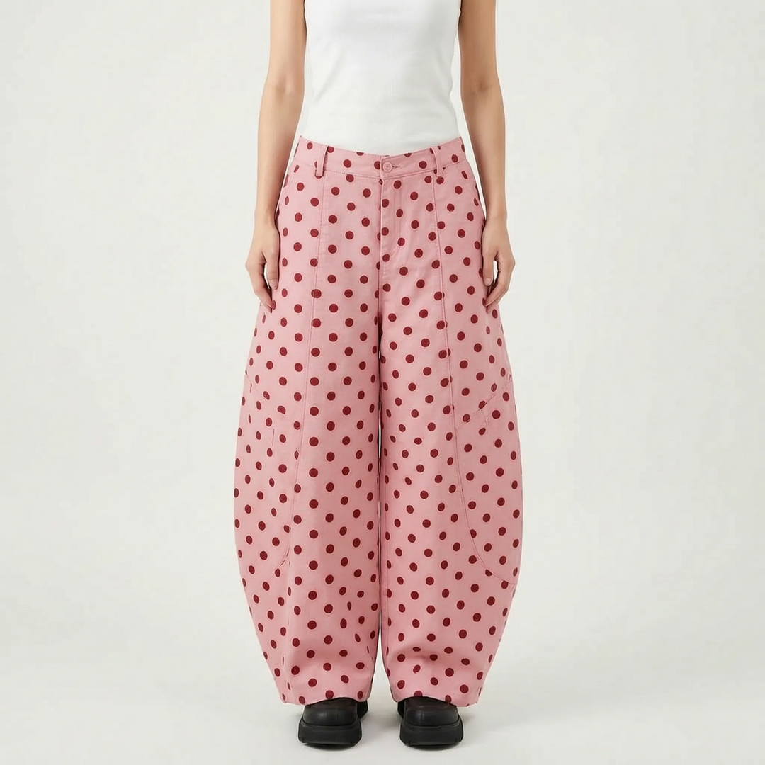 Chic women's pink polka dot barrel-leg pants. High-waisted, wide-leg design offers modern style and comfort.