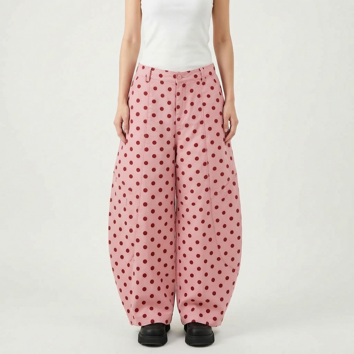 Chic women's pink polka dot barrel-leg pants. High-waisted, wide-leg design offers modern style and comfort.