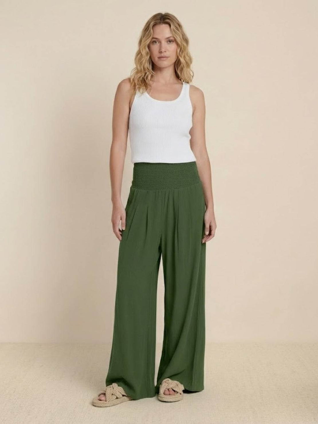 Flowy wide leg smocked trousers for women, high-waisted and relaxed fit, ideal for summer.