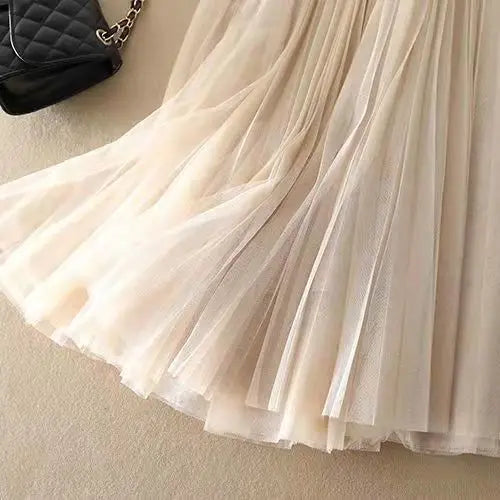 Close-up of the elegant pleats on a women's high-waisted A-line midi skirt, showcasing textile quality.
