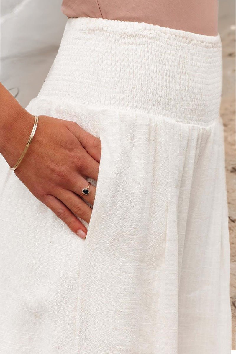 Women's high waisted flowing linen pants with a smocked waistband, versatile and chic.
