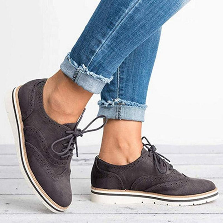 Close-up of Women's Lace-Up Oxford Sneakers in blue, highlighting the intricate brogue details. Smart casual shoes.