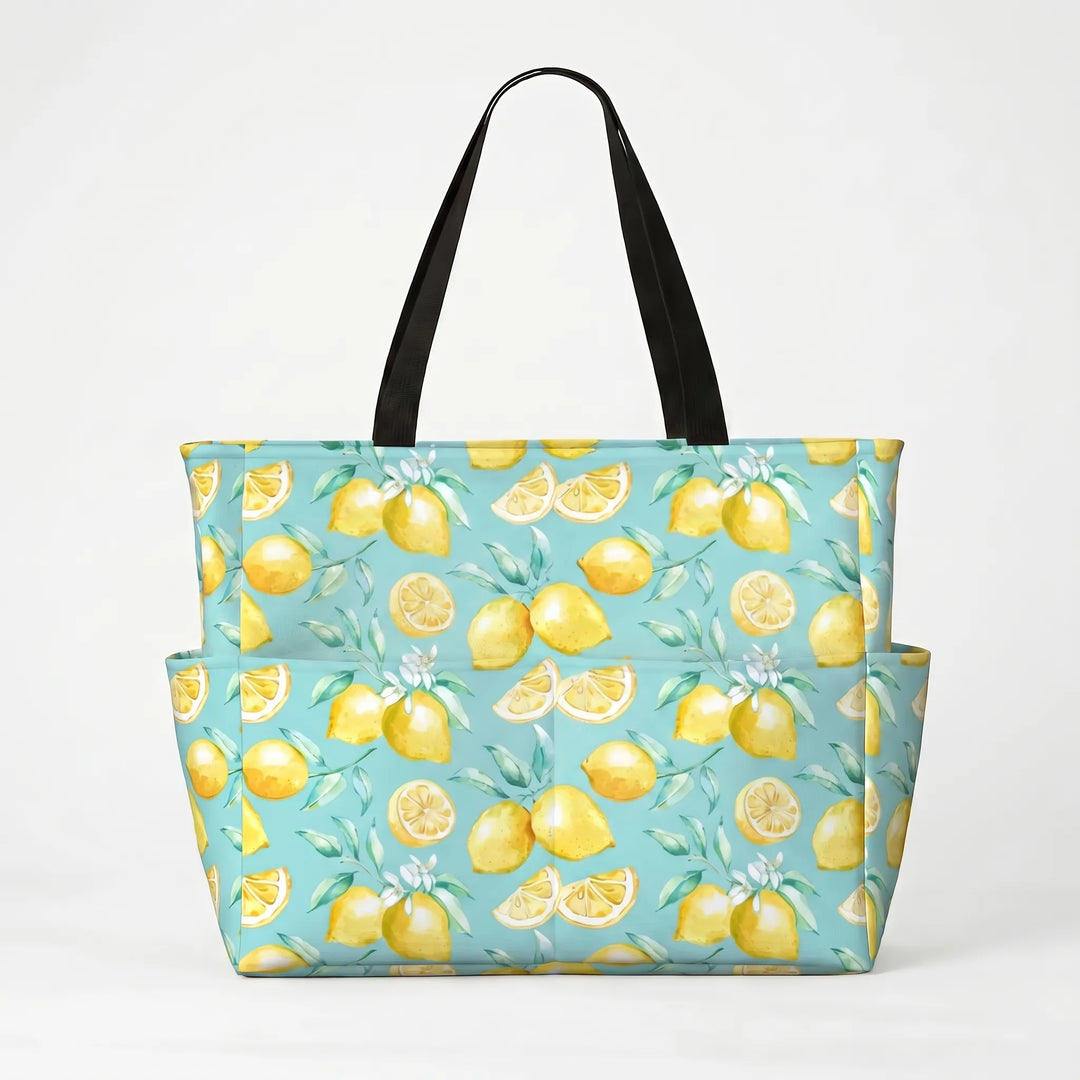 Women's large beach tote bag with tropical lemon print, next to a pool, ready for vacation.