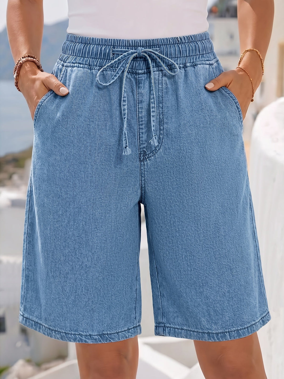 Relaxed fit light blue women's Bermuda shorts, knee-length with comfortable elastic drawstring waist.