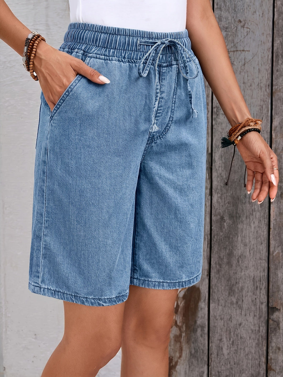 Knee-length light blue women's drawstring Bermuda shorts, wide-leg design for a relaxed summer fit.