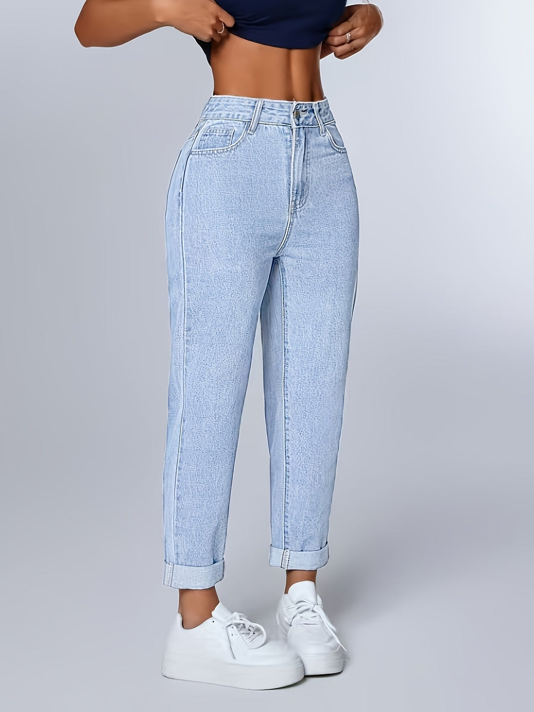 Women's light blue relaxed fit high waist mom jeans with cuffed hem & tapered leg, ideal casual wear.