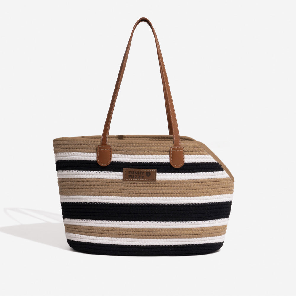 Woman adjusting her small dog in the lightweight cotton woven pet carrier beach bag, ensuring comfort.