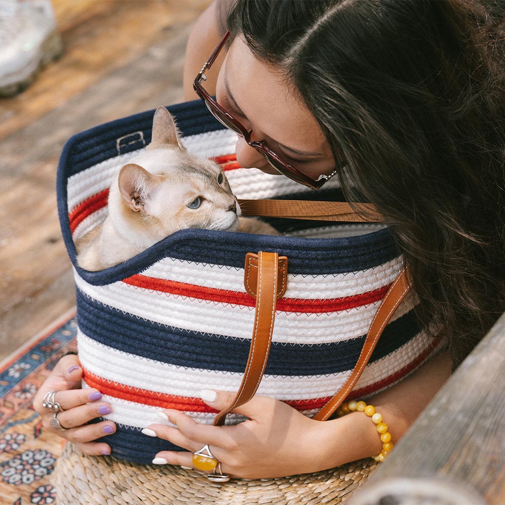Women's lightweight cotton woven pet carrier beach bag with accessories, ready for a beach day with pet.