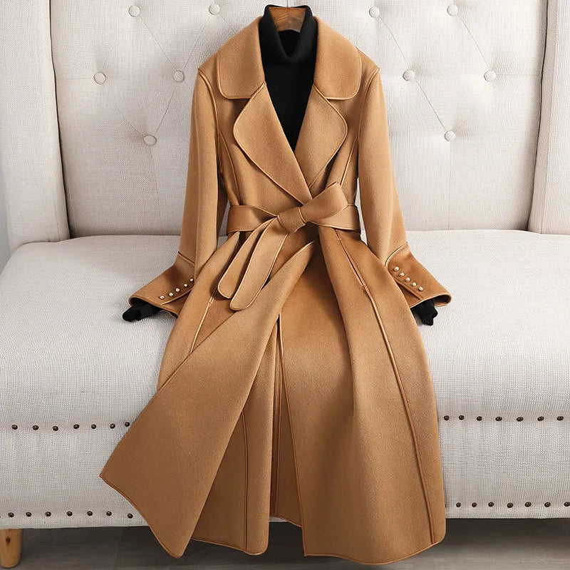 Women's long trenchcoat with belted waist, tailored fit. Classic outerwear for formal or casual fall fashion.