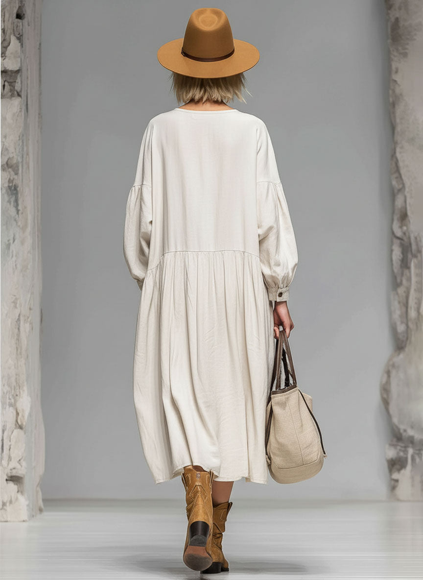 Casual women's button-front midi dress, loose fit, long sleeves, round neck, & pockets. Great for versatile spring style.