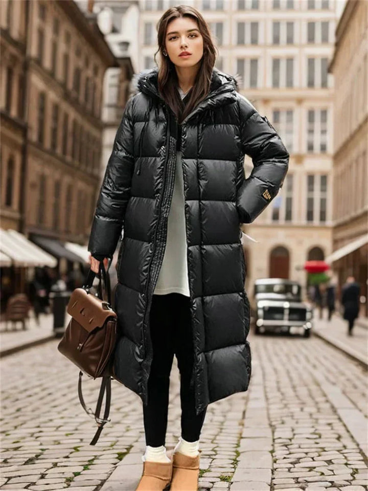 Quilted women's maxi winter coat with hood, designed for warmth and comfort in chilly autumn and winter.