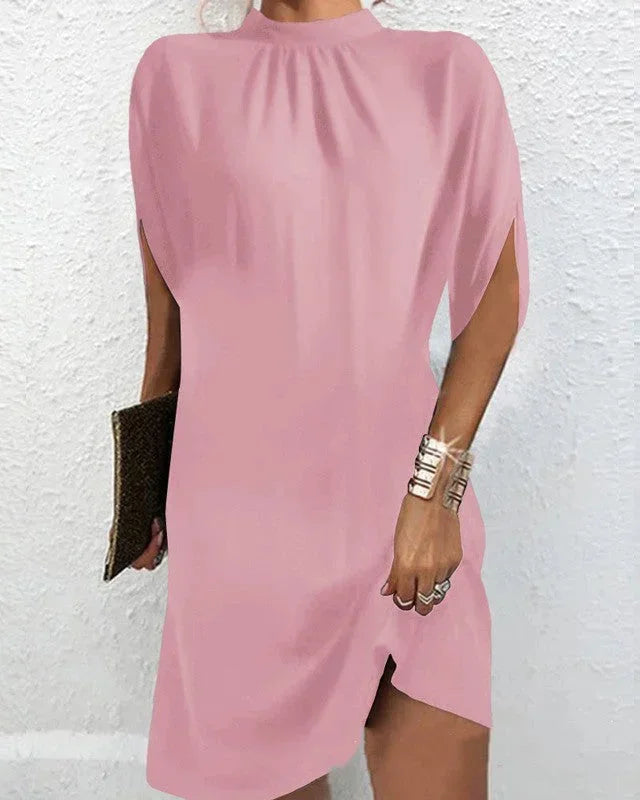 Sophisticated women's party wear mini dress, featuring a mock neck and dramatic cape split sleeves.