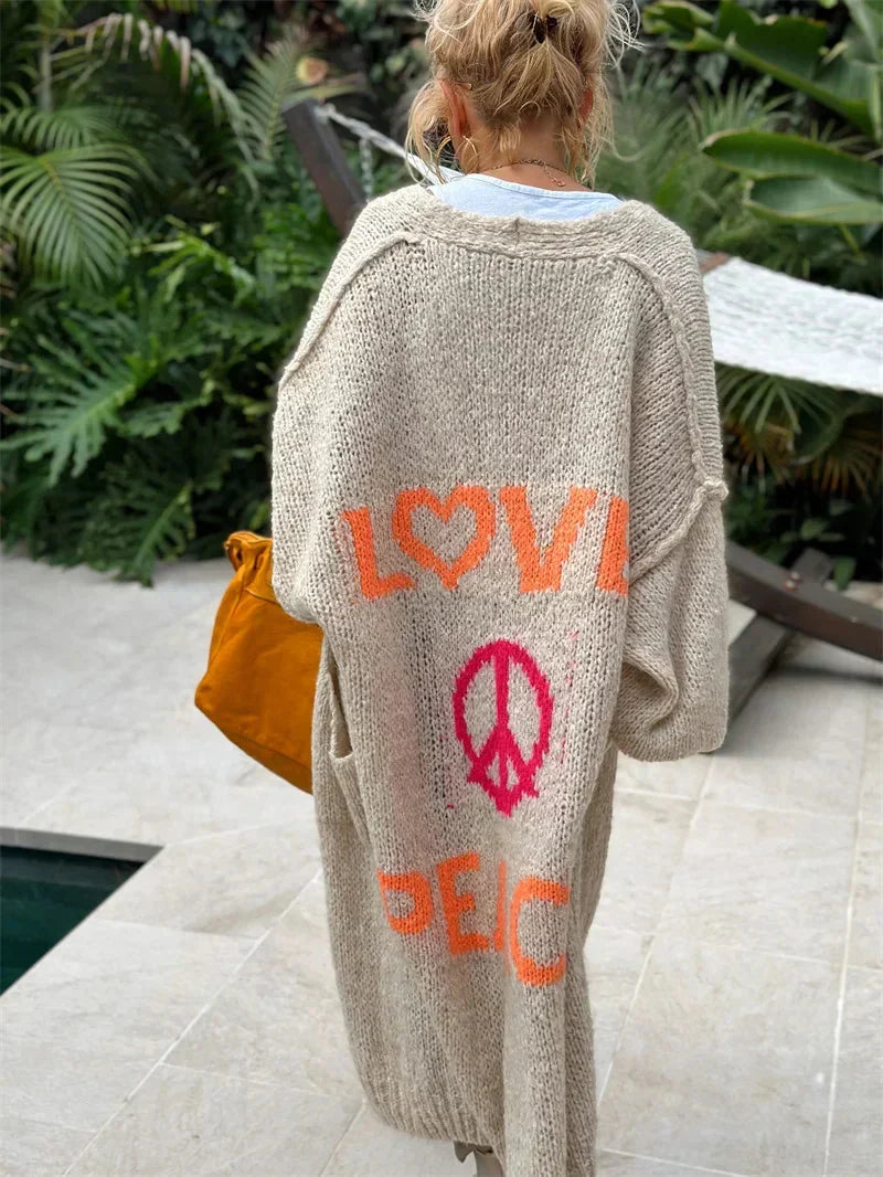 Vibrant, colorful women's long oversized bohemian cardigan, knit with 'Love Peace' slogan.