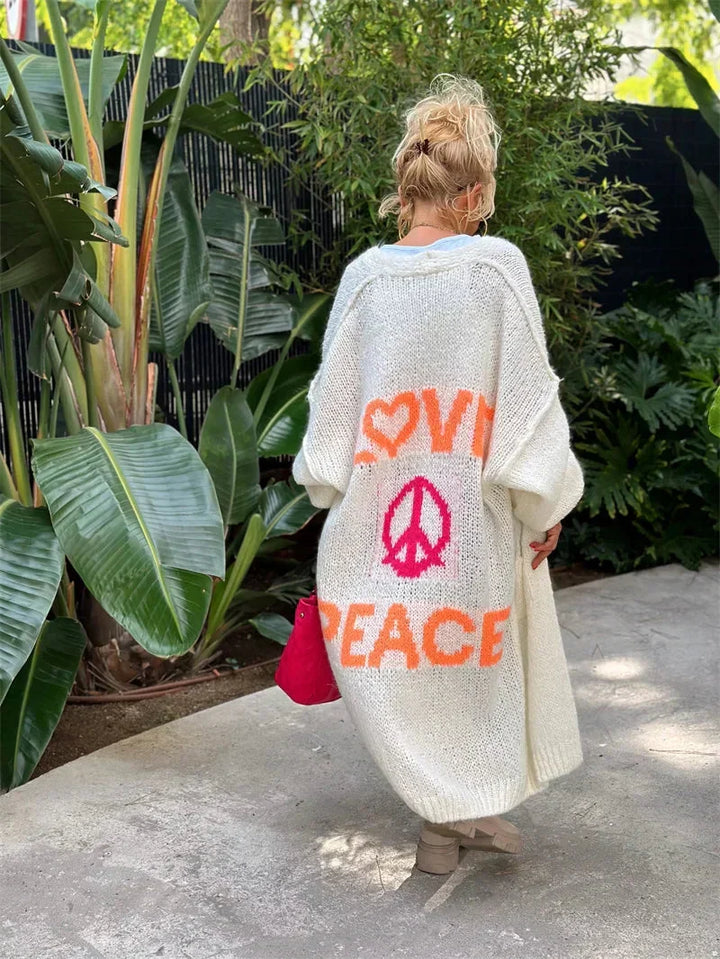Women's long oversized bohemian Faye cardigan, a colorful knit with 'Love Peace' slogan, perfect for layering.
