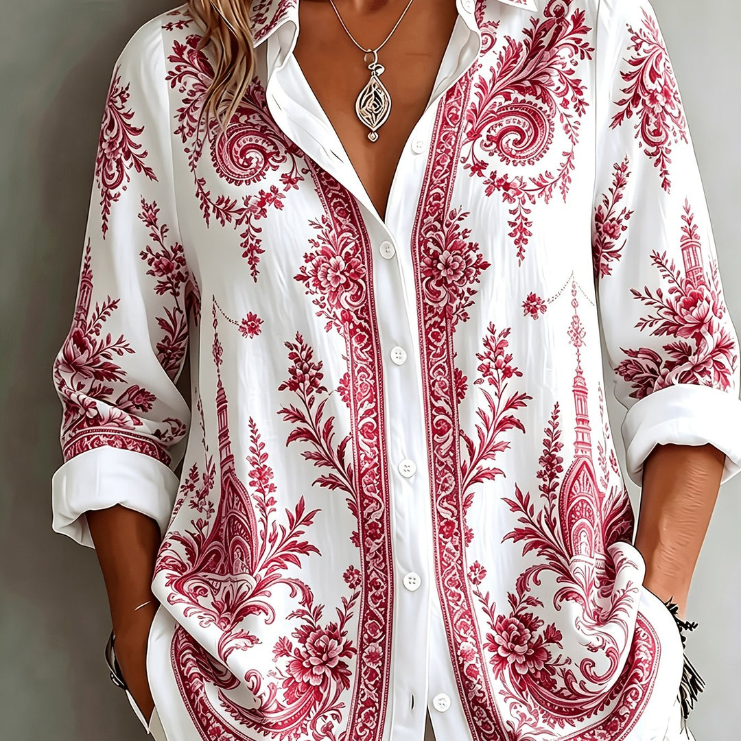 Hanging women's floral paisley oversized long sleeve blouse, highlighting its vibrant print & relaxed style.