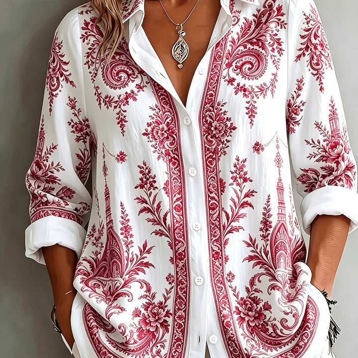 Hanging women's floral paisley oversized long sleeve blouse, highlighting its vibrant print & relaxed style.
