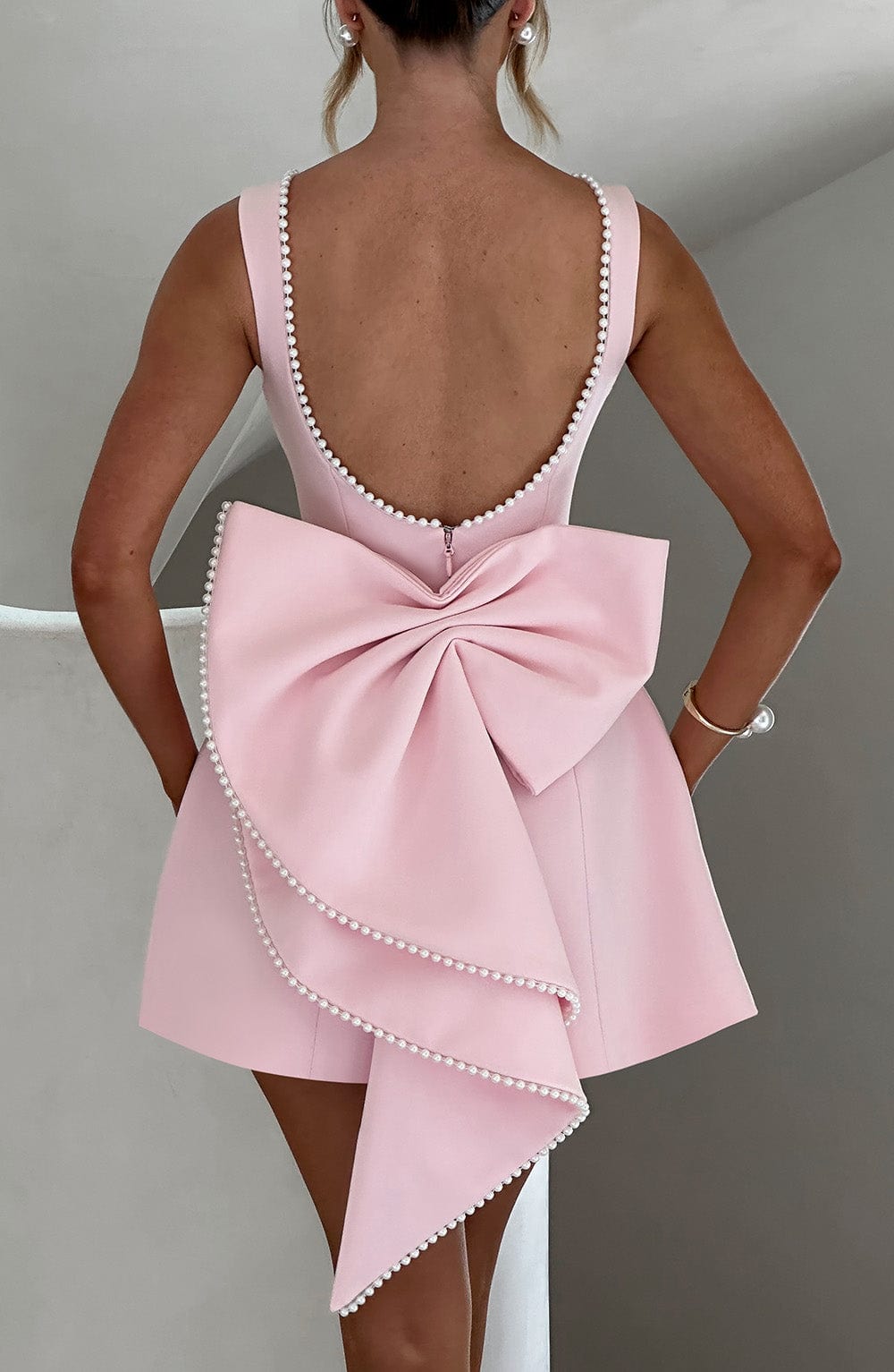 Women's semi-formal mini dress with delicate pearl trim, A-line cut, and bow detail, ideal for homecoming.