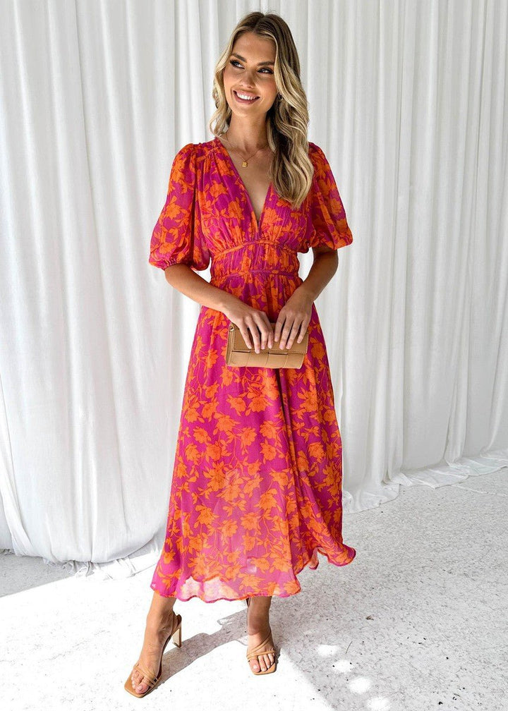 Women's pink orange floral maxi dress with V-neck, flowing style. Perfect for summer vacations.