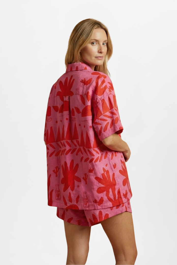 Pink tropical print women's short sleeve camp collar shirt and high-waisted shorts matching set, resort wear.