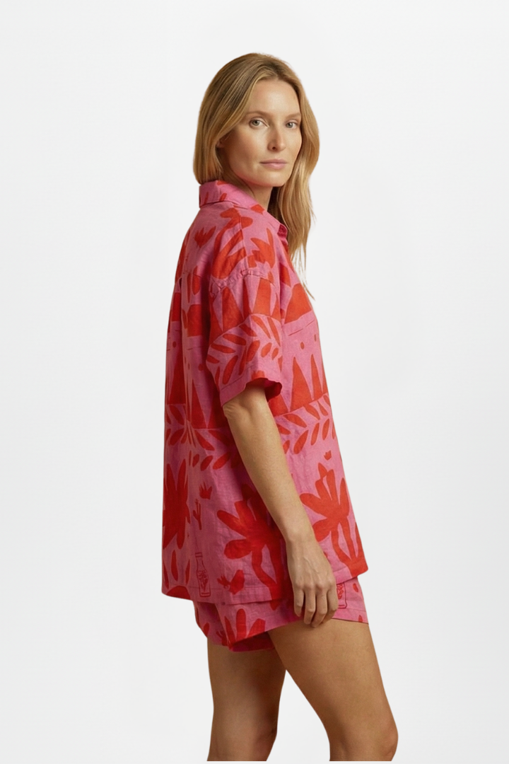 Stylish women's tropical print beach outfit: short sleeve camp collar shirt & high-waisted shorts co-ord set.