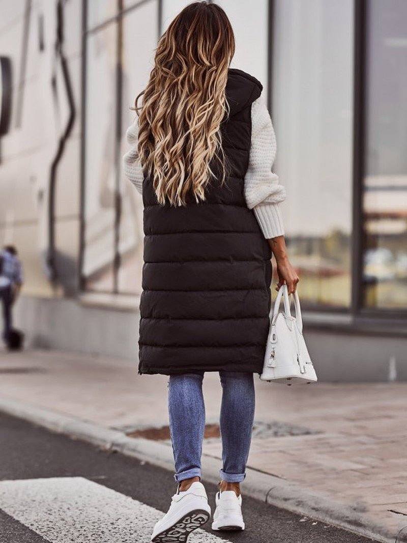 Stylish women's knee-length quilted vest, a warm sleeveless jacket perfect for cold weather & modern layering.
