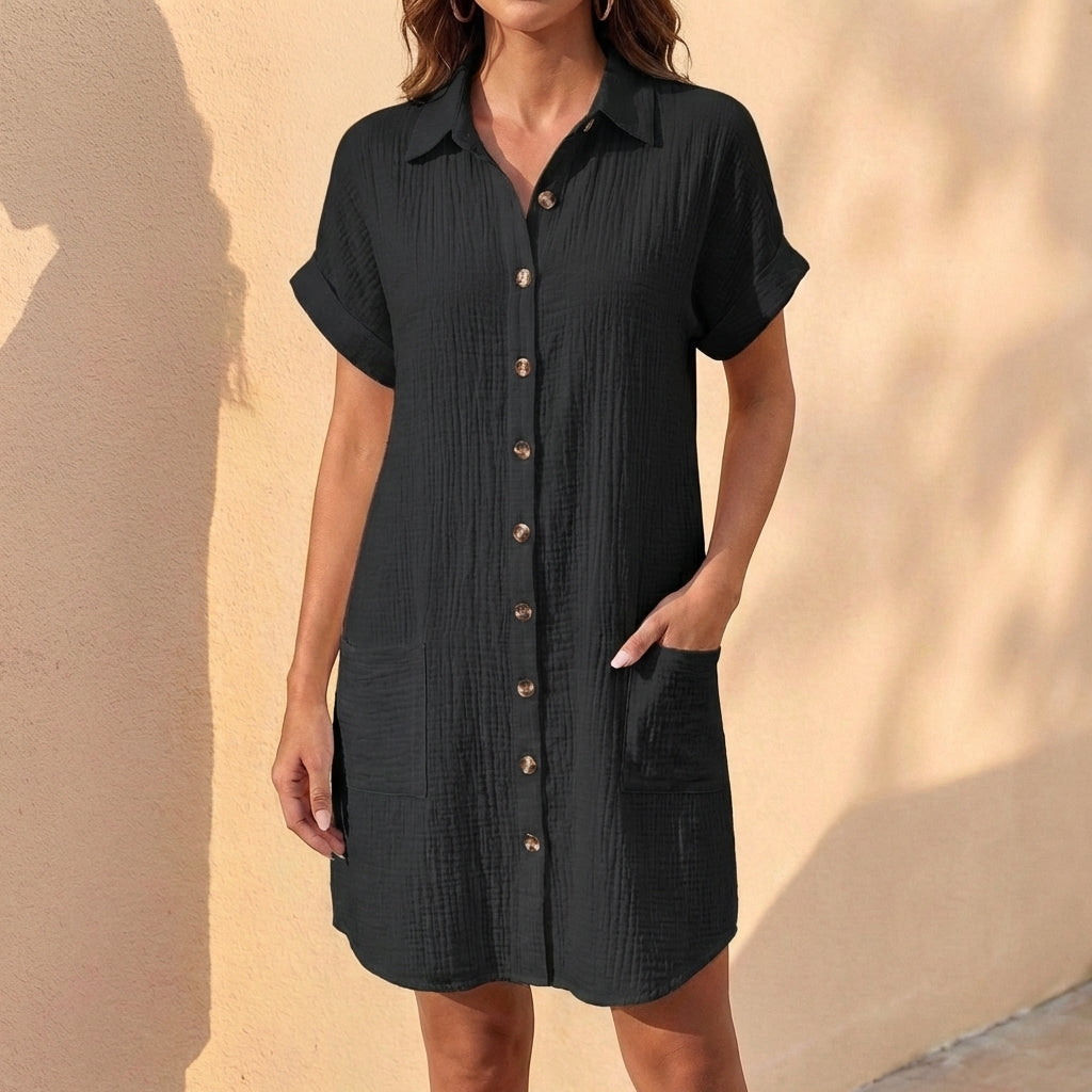 Model wears a women's relaxed fit midi shirt dress, showcasing its comfortable silhouette and cuffed sleeves.