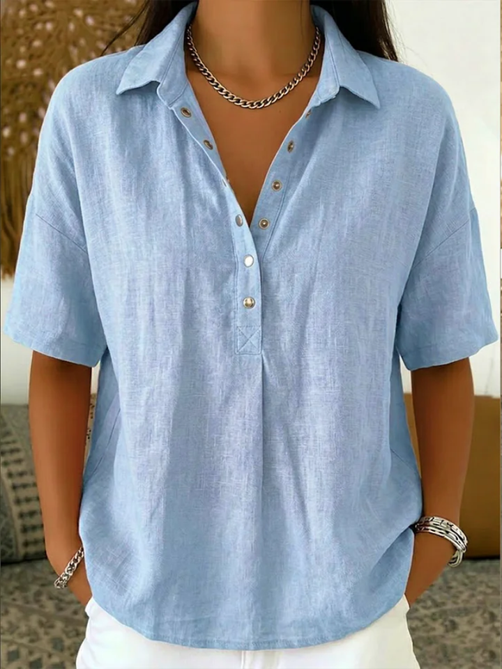 Close-up of women's relaxed fit collar shirt featuring elegant button detail and soft fabric. Chic everyday wear.