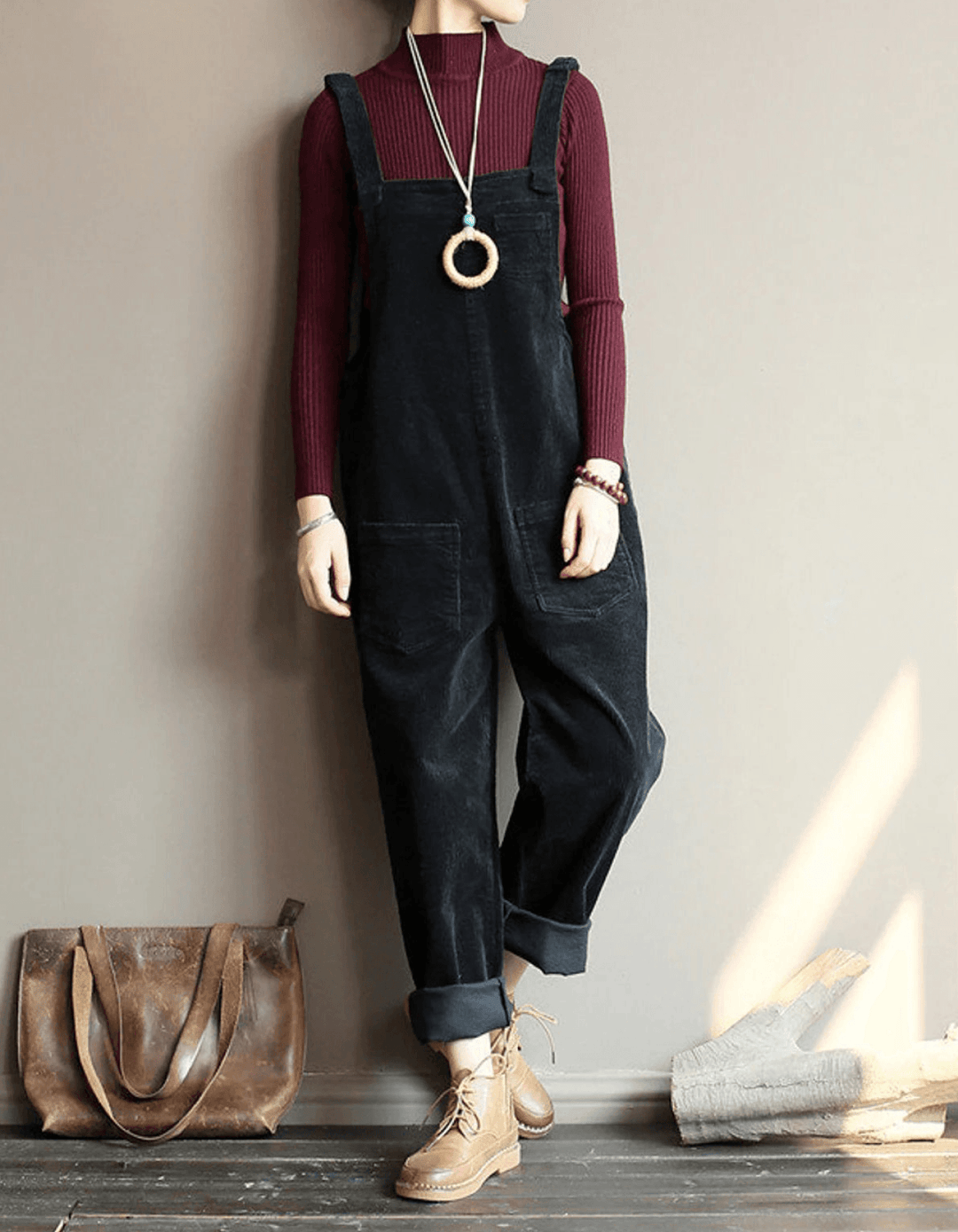 Brown corduroy dungaree jumpsuit for women, featuring a relaxed fit, wide legs, adjustable straps, & front patch pockets.