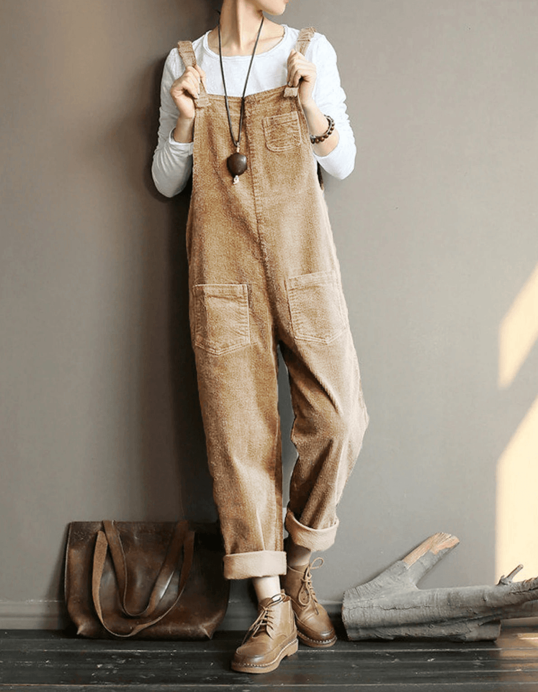 Comfortable women's black corduroy dungaree jumpsuit with a relaxed wide-leg fit, ideal for fall & winter casual wear.