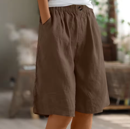 Women's high-waisted Bermuda shorts, relaxed fit, styled casually. Elastic waist for summer comfort and everyday wear.