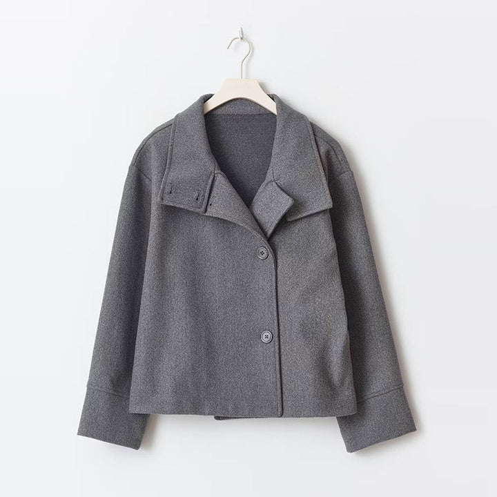Stylish women's short coat: relaxed fit, prominent button closure, cozy high neckline. Winter fashion essential.