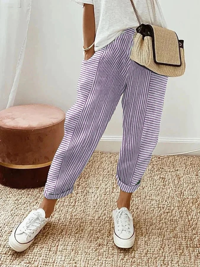 Model relaxing in comfortable women's striped drawstring trousers, showcasing straight leg & versatile casual style.