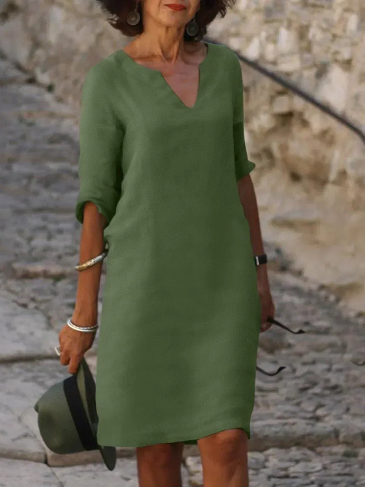 Stylish women's V-neck midi dress with relaxed fit & three-quarter sleeves. Great for casual elegance and comfort.