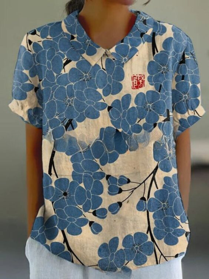 Elegant women's retro short-sleeve top with vibrant floral embroidery, a stylish summer blouse.