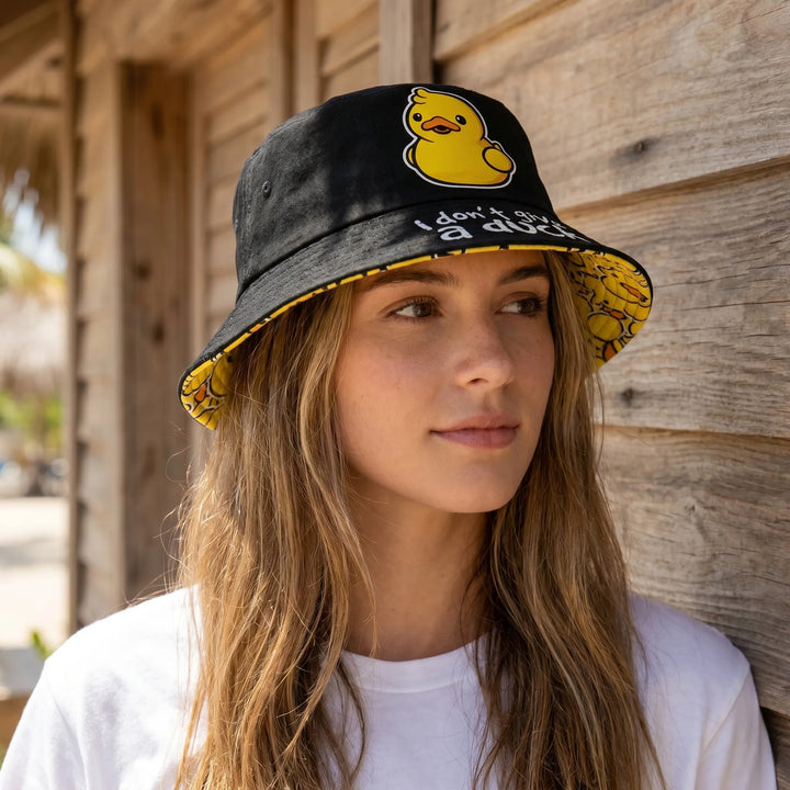 Women's reversible bucket hat with playful duck print on one side & solid color on the other. Perfect for summer fashion.