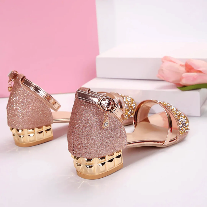 Sparkling women's party sandals with low block heel, dazzling rhinestones, and an eye-catching chain ankle strap.