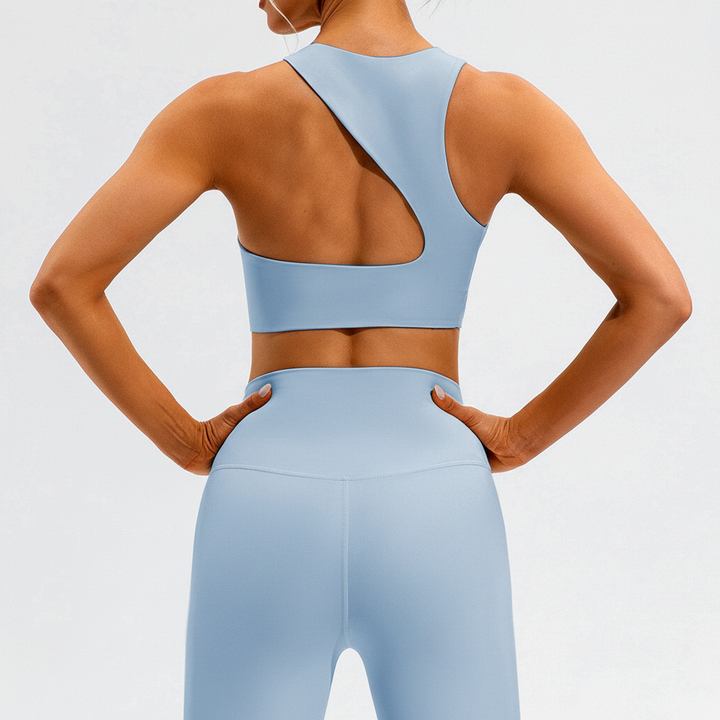 Woman in a dynamic pose wearing a seamless activewear set: performance top & high-waist leggings for yoga.