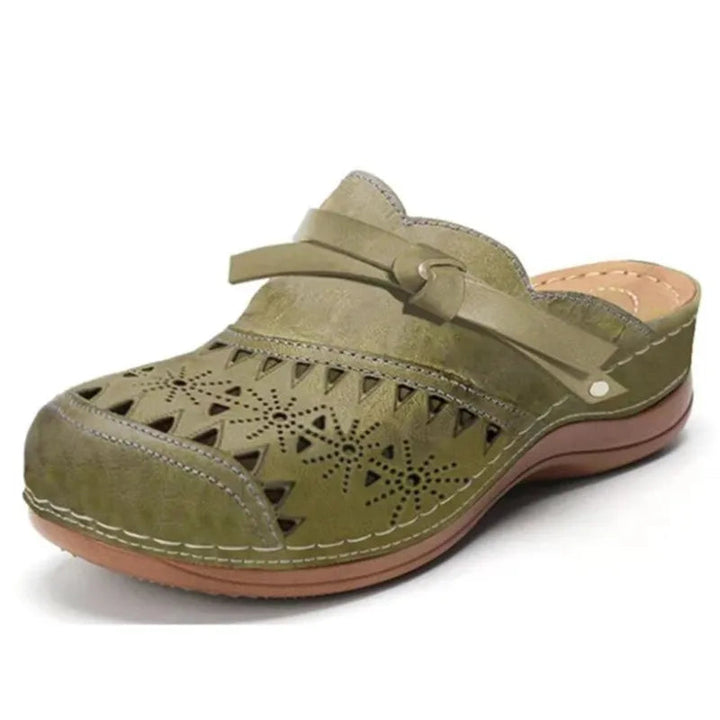 Side view of women's comfortable slip-on clogs, highlighting the bow accent and elegant cutout design.