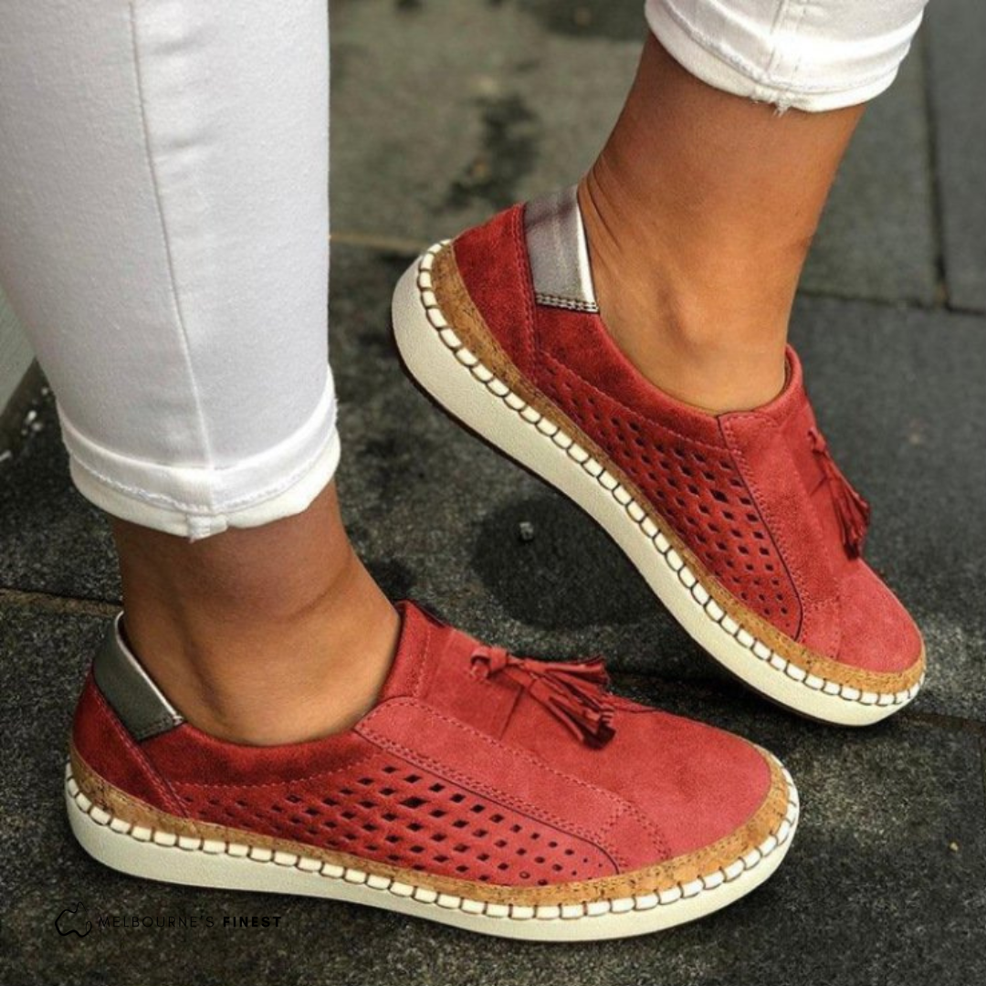 Women's slip-on loafers with perforated design & decorative tassels. Comfortable flat shoes for casual everyday wear.