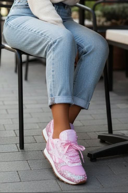 Close-up of women's sequin sneakers with shimmering glitter, lace-up style. Fashionable casual footwear.