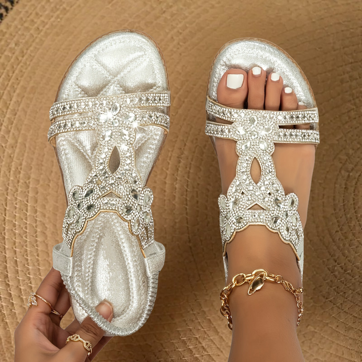 Stylish women's flat summer sandals with shimmering rhinestone details for fashion footwear.