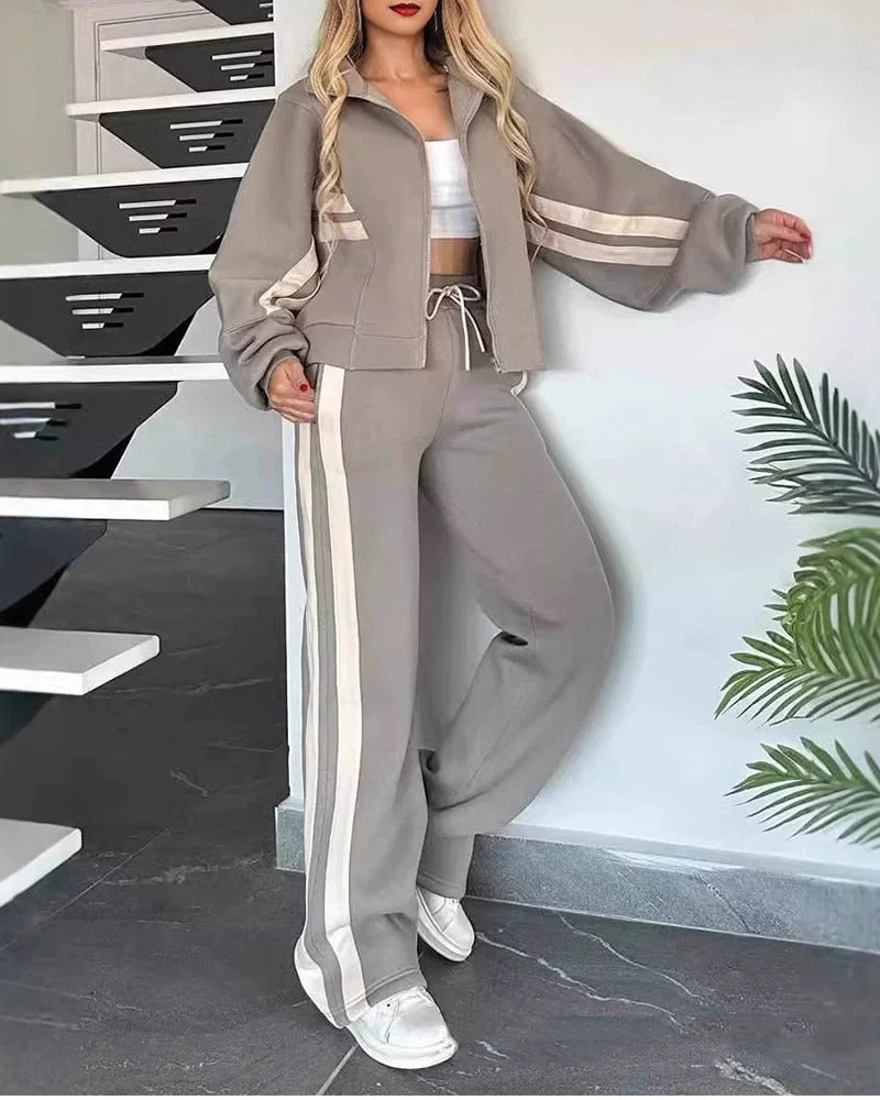 Womens coordinated lounge wear set: sporty zip-up jacket & wide leg trousers with chic contrast stripes.